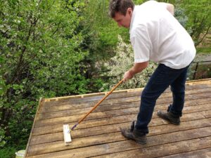 Man cleaning wooden deck